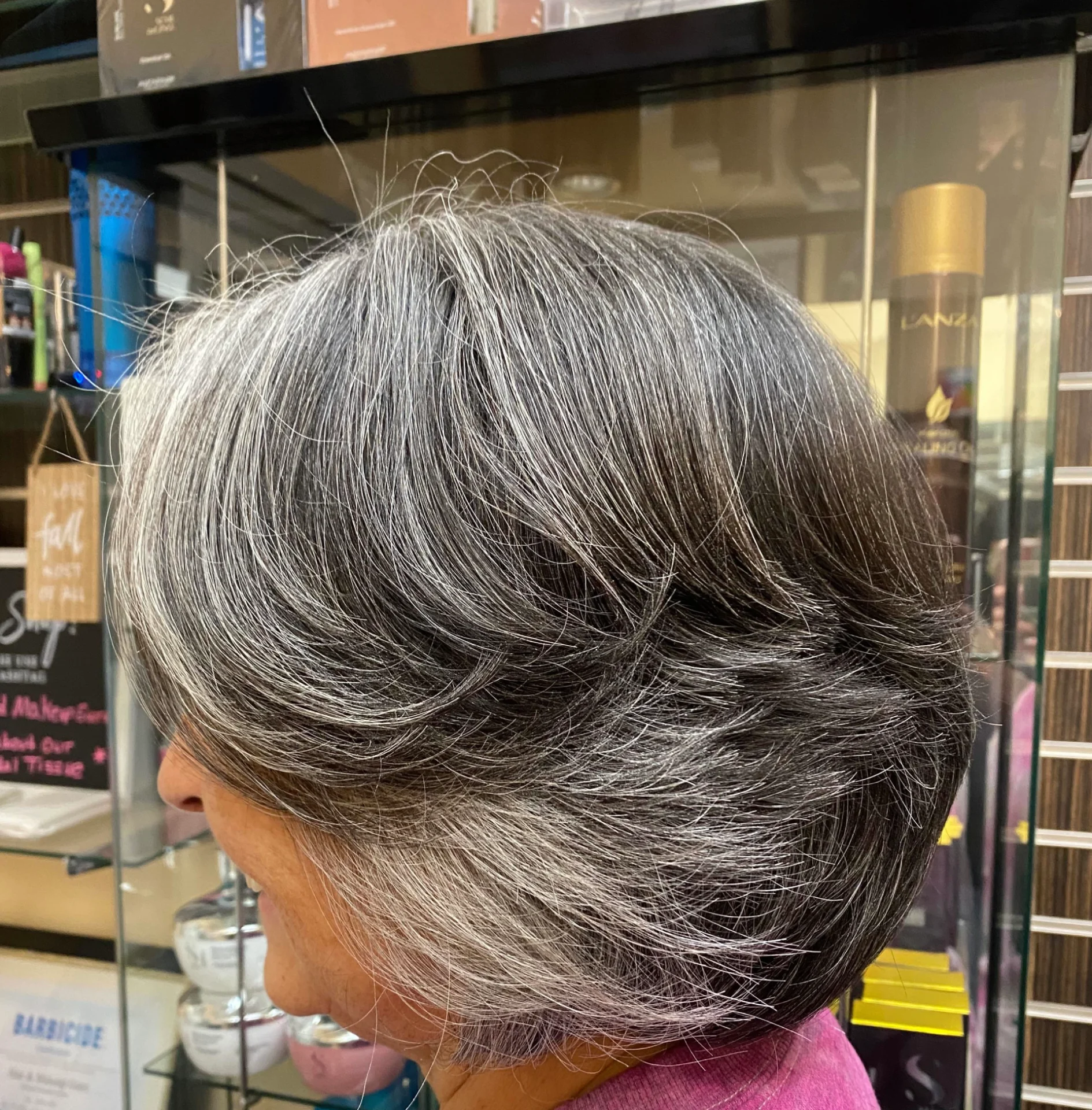 A woman with gray hair is looking at the camera.